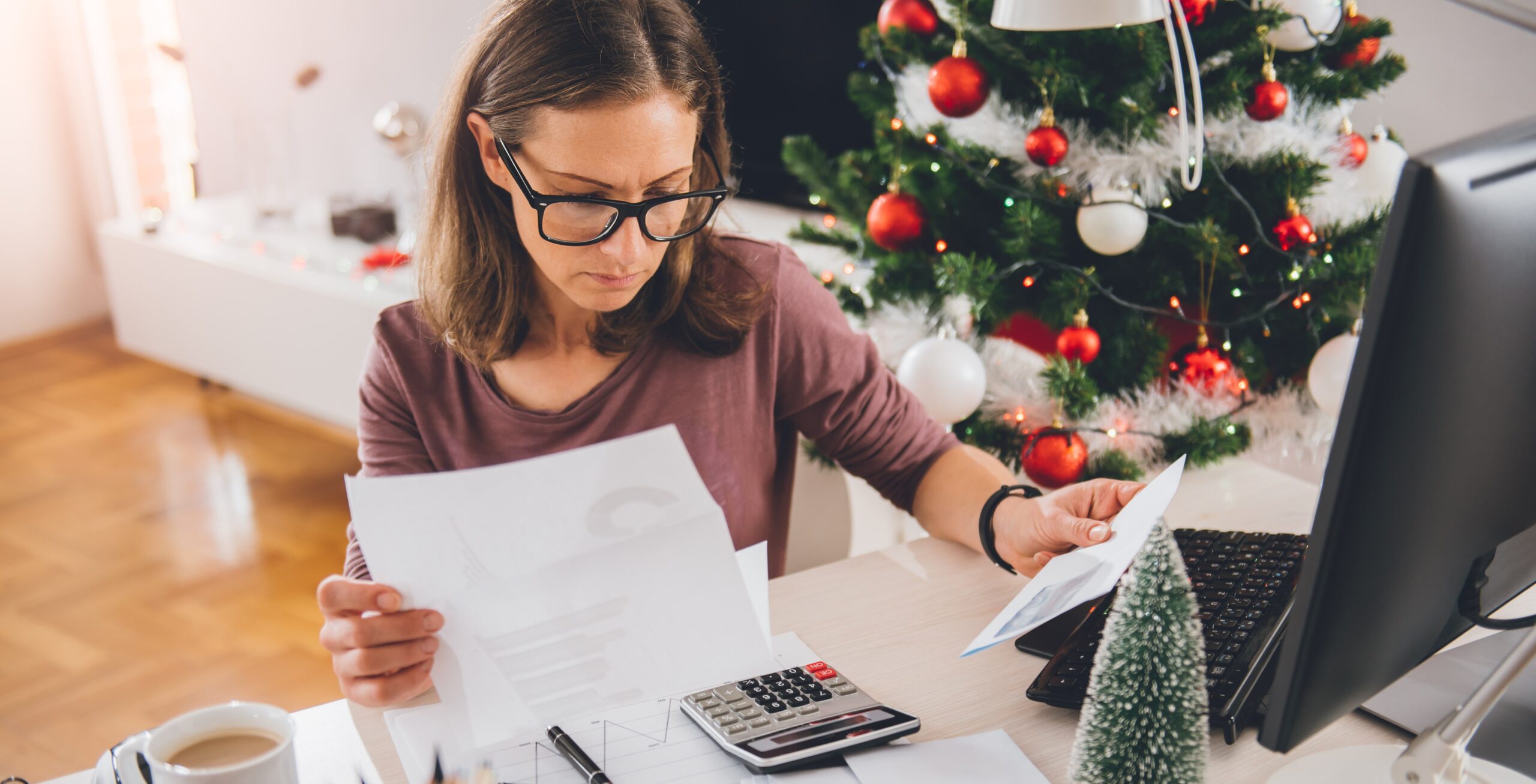 mujer sentada mirando facturas de navidad