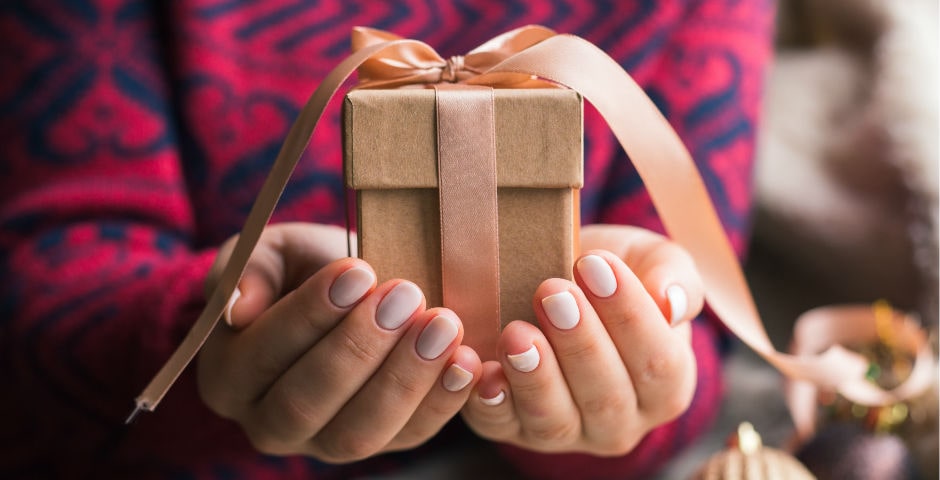 Mans aguantant un regal de Nadal amb consum responsable