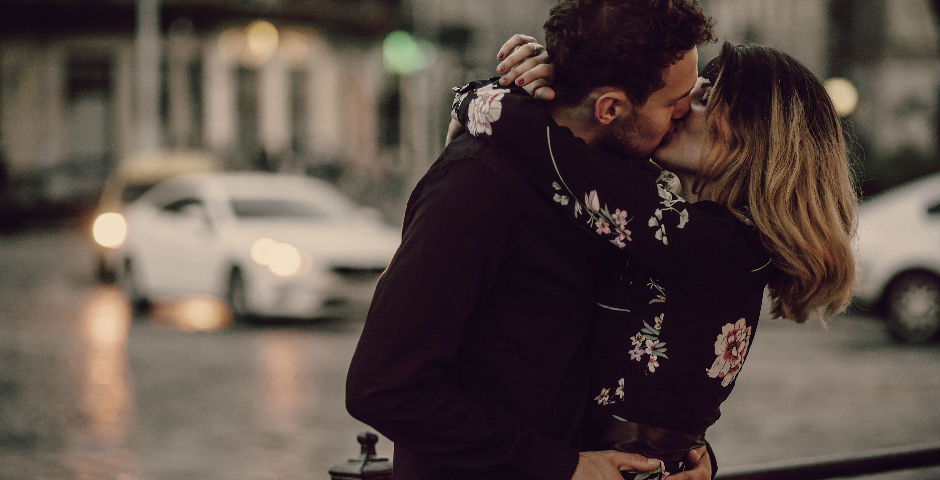 Hombre y mujer dándose un beso celebrando el día internacional del beso