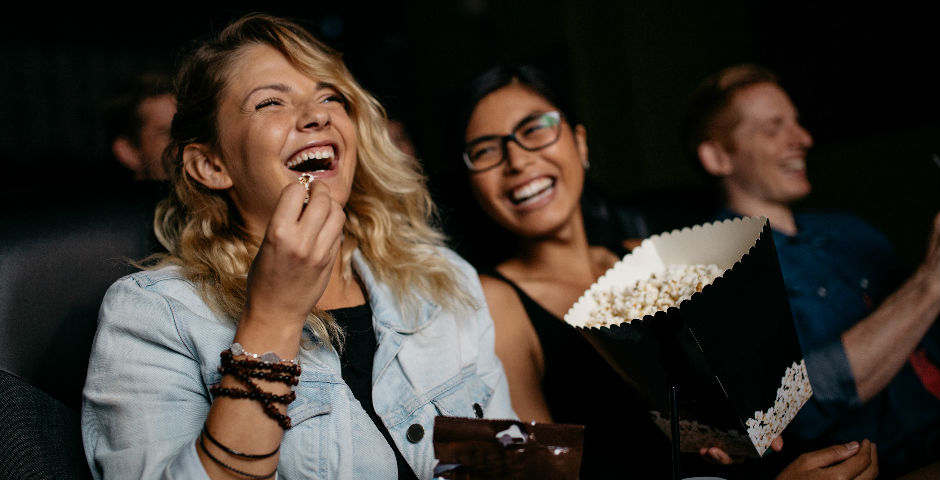 Dos chicas disfrutando de una película en el cine gracias al método de ahorro 50/20/30
