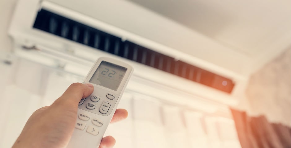 Persona ahorrando energía con el aire acondicionado de su casa