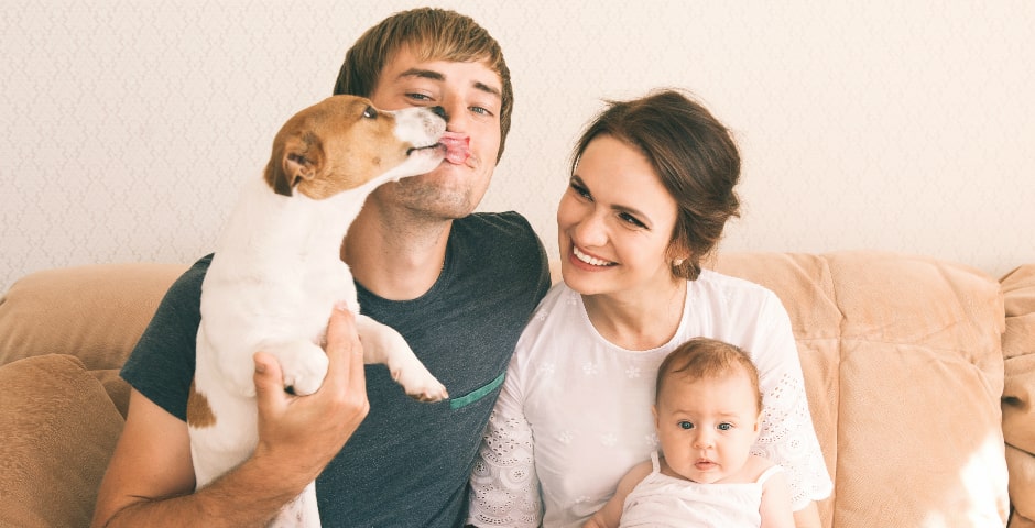 Familia feliç amb un gos com a mascota