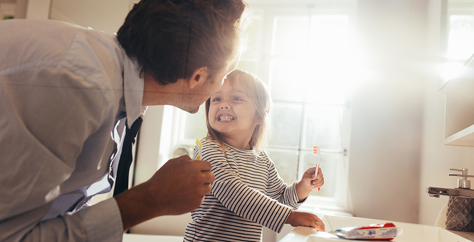 Padre e hija cepillándose los dientes