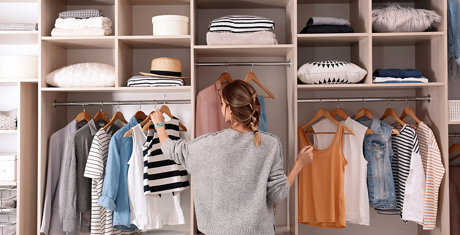 Mujer ordenando su armario de ropa y complementos