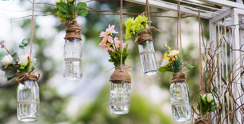 Botellas reutilizadas como floreros para decorar el jardín