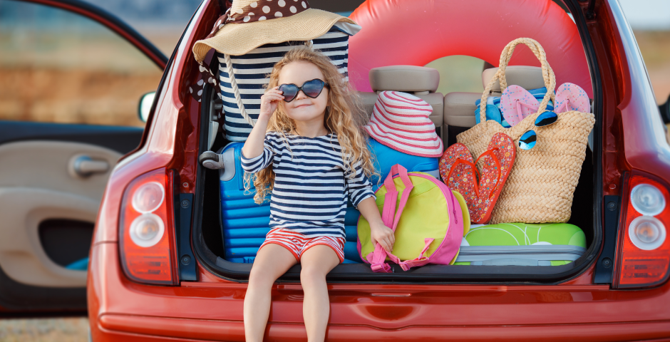 niña sentada en el maletero de un coche