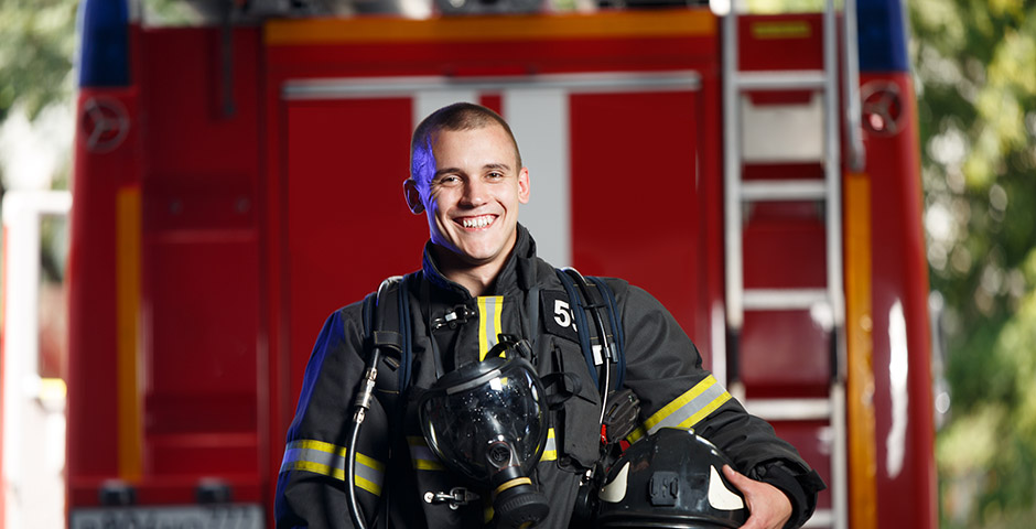 Joven bombero sonriendo a cámara