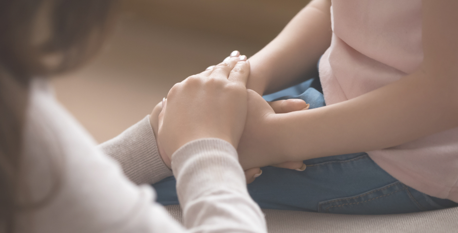 Mujer cogiendo las manos de un niño