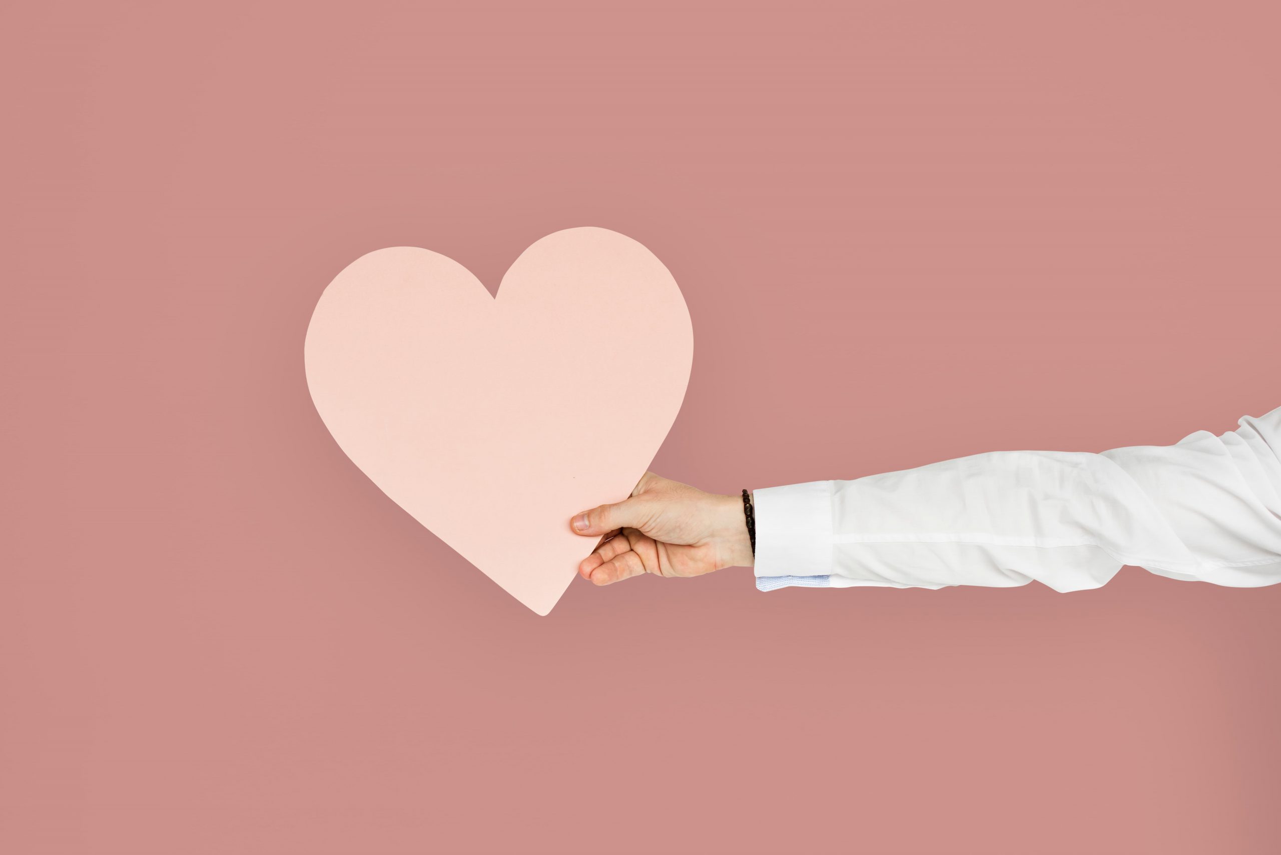 hand holding a pink heart cutout healthy heart scaled